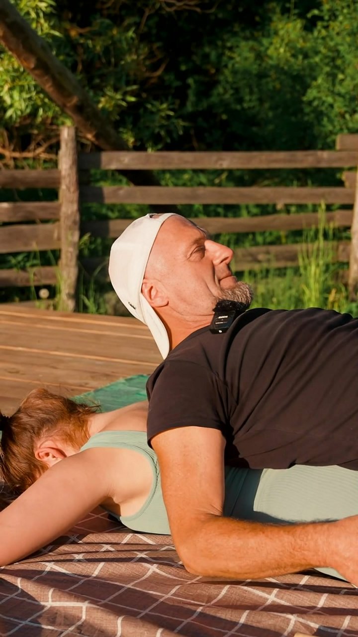 Could this simple partner exercise decompress your lumbar spine? The base partner lies supine while the receiver is prone, back-to-chest. Hands are placed on the lumbar region for tactile feedback. Through synchronized diaphragmatic breathing, the abdomin